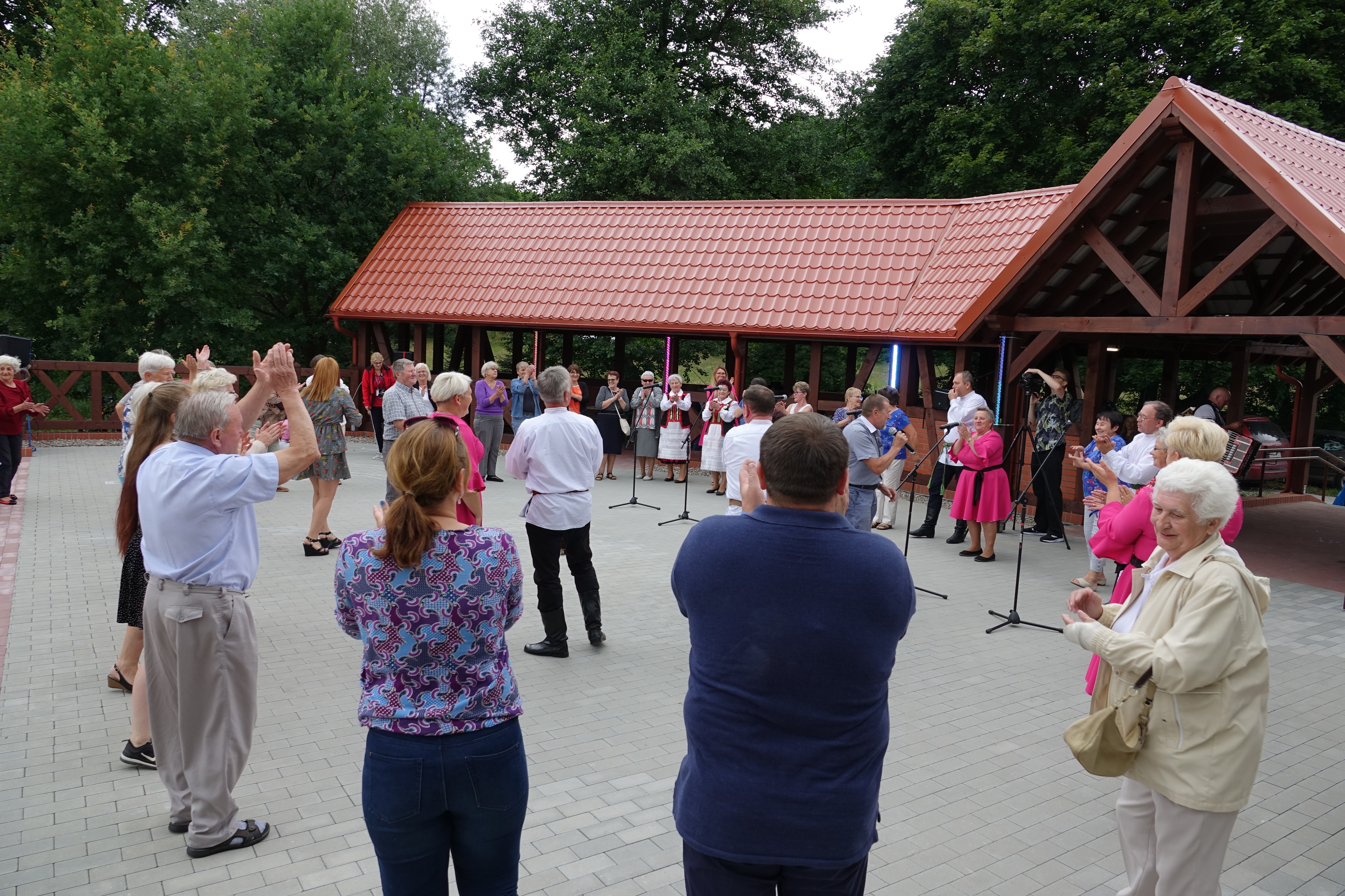 Uczestnicy biesiady podczas śpiewu zgromadzeni na placu.