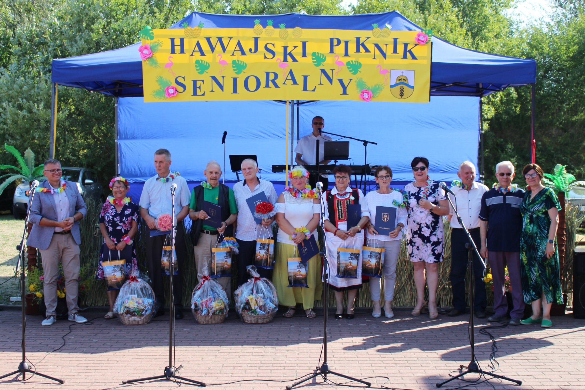 Uczestnicy konkursu Srebrne Serce pod sceną w towarzystwie przewodniczącego Rady Gminy Główczyce, Wójt Gminy Główczyce, przewodniczącego Rady Seniorów Gminy Główczyce oraz kierownika OPS